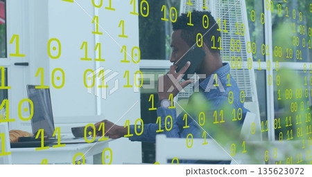 Man typing on laptop and talking on smartphone on terrace, with floating binary code 135623072