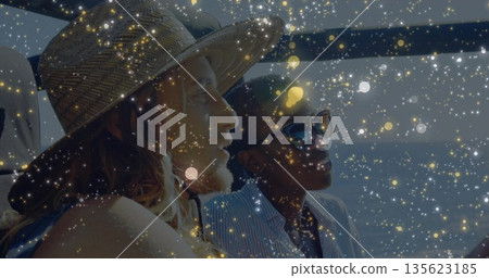 Sitting couple wearing striped shirt on boat seating, with straw hat, sunglasses and metal rail Sitting couple wearing striped shirt on boat seating, with straw hat, sunglasses and metal rail 135623185