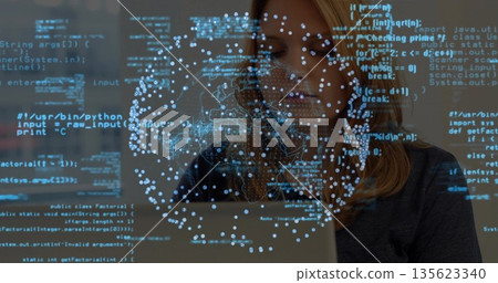 Working software developer coding on laptop in workspace, with blue code data visualization network 135623340