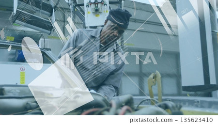 Leaning mechanic in coveralls and cap inspecting engine hoses in repair bay with diagnostic overlay Leaning mechanic in coveralls and cap inspecting engine hoses in repair bay with diagnostic overlay 135623410