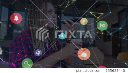 Sitting man in checkered shirt holding smartphone and coffee cup at cafe, with social media icons 135623440