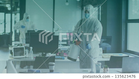 Spraying technician wearing protective suit disinfecting desks in office with sprayer, copy space Spraying technician wearing protective suit disinfecting desks in office with sprayer, copy space 135623476