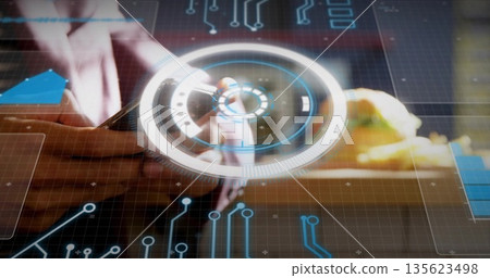 Designer manipulating circular hologram at wooden desk, with stylus and circuit graphics Designer manipulating circular hologram at wooden desk, with stylus and circuit graphics 135623498