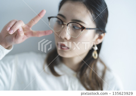 一位戴眼鏡的女士比出和平手勢 135623929