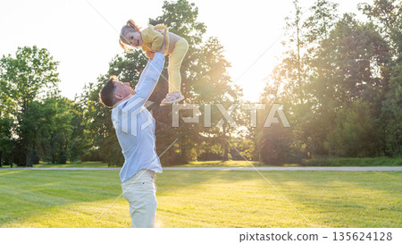 Family bonding. Father lifting daughter during outdoor play. Family bonding. Father lifting daughter during outdoor play. 135624128