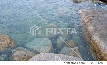 Crystal Clear Sea Water Washing Over Granite Rocks at Siangau Beach Coastline Bangka Belitung 135624280