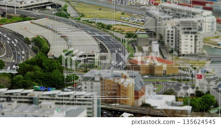Showing aerial highway interchange curving over urban area, with vehicles, digital overlays 135624545