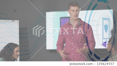 Presenting man in red shirt explaining interface graphics on screen in meeting room with whiteboard Presenting man in red shirt explaining interface graphics on screen in meeting room with whiteboard 135624557