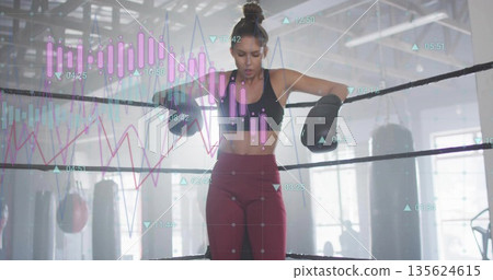 Leaning boxer wearing black sports bra, leggings, breathing in boxing ring with gloves data overlay Leaning boxer wearing black sports bra, leggings, breathing in boxing ring with gloves data overlay 135624615