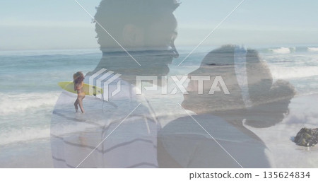 Smiling couple standing at seaside beach, with yellow surfboard, rolling waves and rocky outcrop Smiling couple standing at seaside beach, with yellow surfboard, rolling waves and rocky outcrop 135624834