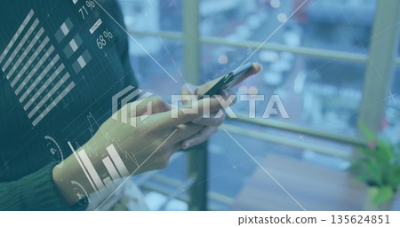 Showing professional hands analyzing financial data on smartphone at cafe, with table and plant 135624851