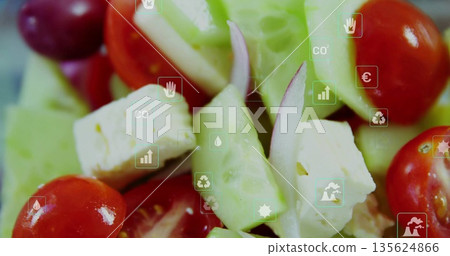 Displaying salad on counter with cucumber, tomatoes, red onion and cheese cubes with floating icons Displaying salad on counter with cucumber, tomatoes, red onion and cheese cubes with floating icons 135624866