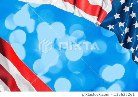 American and patriotic flags arranged against a blue background with bokeh effect 135625261