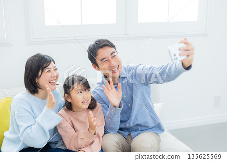 Family looking at a smartphone in the living room 135625569