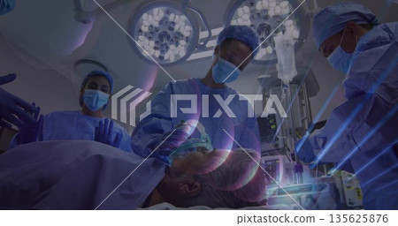 Performing surgery lead surgeon guiding team around patient in operating room, with anesthesia mask Performing surgery lead surgeon guiding team around patient in operating room, with anesthesia mask 135625876