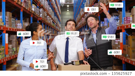 Warehouse team analyzing box in busy aisle, with pallet truck, label gun, floating icons Warehouse team analyzing box in busy aisle, with pallet truck, label gun, floating icons 135625927