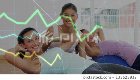 Three women doing abs workout in gym studio, with colored mats, stability ball, translucent overlay Three women doing abs workout in gym studio, with colored mats, stability ball, translucent overlay 135625932
