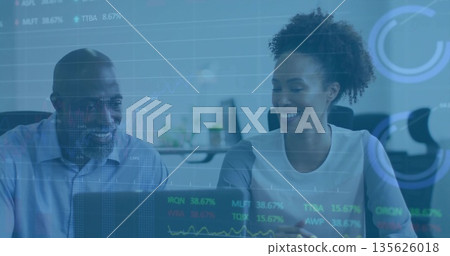 Reviewing financial data on laptop, coworkers in business attire analyzing charts in office Reviewing financial data on laptop, coworkers in business attire analyzing charts in office 135626018
