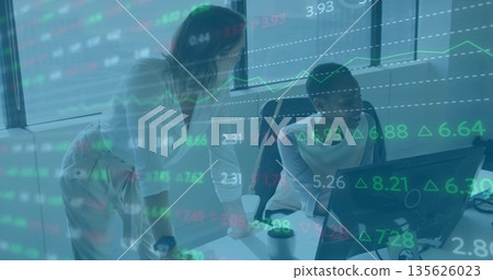 Reviewing stock data colleagues in business attire collaborating at office desk, with coffee cup 135626023