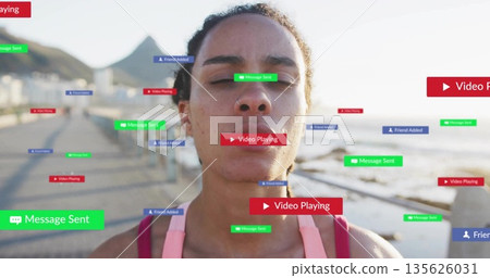 Standing woman wearing pink sports top on waterfront promenade, with digital notification overlays Standing woman wearing pink sports top on waterfront promenade, with digital notification overlays 135626031