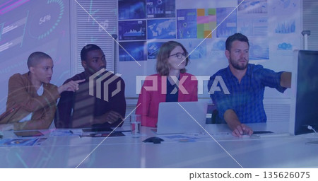 Four professionals reviewing data in conference room, with laptop monitor and charts Four professionals reviewing data in conference room, with laptop monitor and charts 135626075