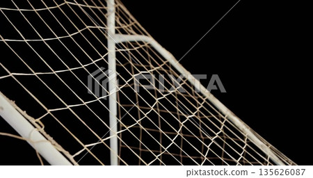 Displaying soccer goal corner with metal posts supporting diamond netting against black background Displaying soccer goal corner with metal posts supporting diamond netting against black background 135626087