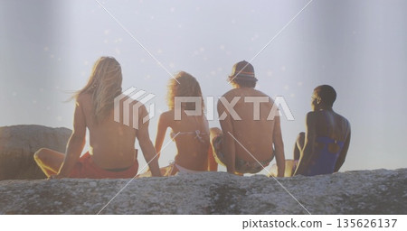 Basking group of friends soaking up warm sunlight on coastal rock outcrop, swimwear and bucket hat Basking group of friends soaking up warm sunlight on coastal rock outcrop, swimwear and bucket hat 135626137