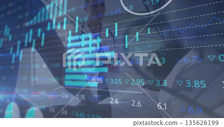 Holding laptop in blazers, pointing tablet screen, analyzing market trends on data charts at office Holding laptop in blazers, pointing tablet screen, analyzing market trends on data charts at office 135626199