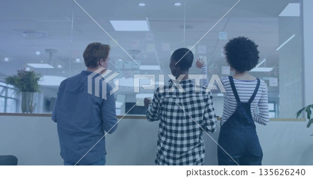 Collaborating colleagues placing and rearranging sticky notes in office, glass wall with diagrams Collaborating colleagues placing and rearranging sticky notes in office, glass wall with diagrams 135626240
