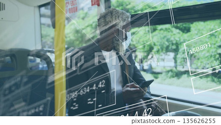 Commuter in face mask, suit jacket using smartphone on train by window, with data overlays Commuter in face mask, suit jacket using smartphone on train by window, with data overlays 135626255