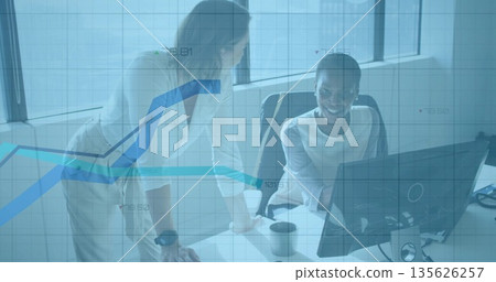 Coworkers in business attire analyzing data at modern office desk, with digital graph overlay Coworkers in business attire analyzing data at modern office desk, with digital graph overlay 135626257