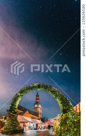Riga, Latvia. Traditional Christmas Market On Dome Square With Cathedral. Famous Landmark In Winter Evening Night In Festive Illuminations Lighting 135626580