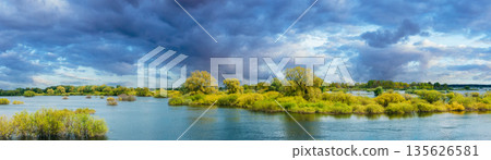 Panoramic View Countryside Landscape During Spring Flood Floodwaters. Tranquil Bold Bright Blue Sky Above Nature Landscape During Spring Flood. Amazing Reflections In River. Musical Calmness Concept Panoramic View Countryside Landscape During Spring Flood Floodwaters. Tranquil Bold Bright Blue Sky Above Nature Landscape During Spring Flood. Amazing Reflections In River. Musical Calmness Concept 135626581