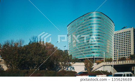 Contemporary cylindrical building with horizontal stripes in Beijing park area during autumn season Contemporary cylindrical building with horizontal stripes in Beijing park area during autumn season 135626689