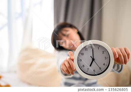 一名女子拿著鬧鐘 135626805