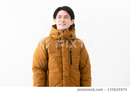 Young man wearing a down coat 135626974