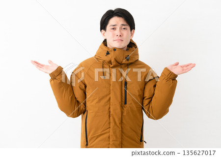 Young man wearing a down coat 135627017