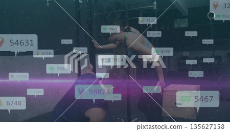 Executing muscle-up adult female athlete wearing gymwear on pull-up rig in gym with floating stats Executing muscle-up adult female athlete wearing gymwear on pull-up rig in gym with floating stats 135627158