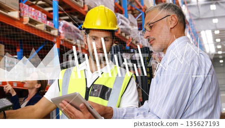 Reviewing stock two colleagues wearing vest examining tablet at warehouse, with scanner and charts Reviewing stock two colleagues wearing vest examining tablet at warehouse, with scanner and charts 135627193