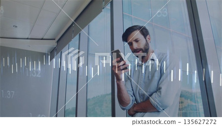 Checking man wearing blue shirt beside glass windows in office, with smartphone and data overlays 135627272