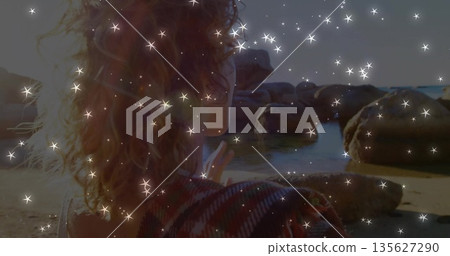 Woman in red-black jacket gazing on rocky shoreline, with tide pools and digital sparkle overlay Woman in red-black jacket gazing on rocky shoreline, with tide pools and digital sparkle overlay 135627290