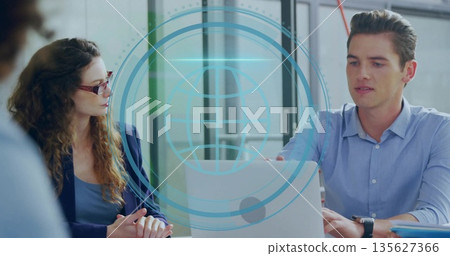 Engaging male professional typing on laptop at office meeting table, with digital globe overlay Engaging male professional typing on laptop at office meeting table, with digital globe overlay 135627366