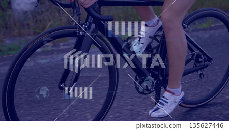 Pedaling cyclist on black bicycle wearing cycling shorts and shoes on park path, with data graphics 135627446