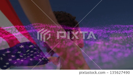 Holding American flag woman wearing tank top gazing toward horizon at beach, with glitch effect Holding American flag woman wearing tank top gazing toward horizon at beach, with glitch effect 135627490