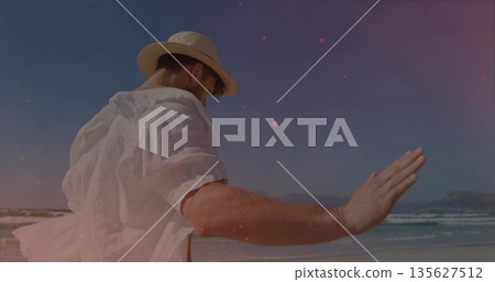 Pointing man in straw fedora hat, white linen shirt extending arm toward sea shore, copy space Pointing man in straw fedora hat, white linen shirt extending arm toward sea shore, copy space 135627512