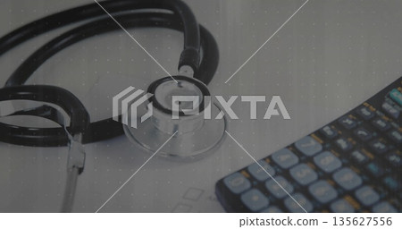 Arranging medical stethoscope and calculator on clinic desk surface, with printed sheet Arranging medical stethoscope and calculator on clinic desk surface, with printed sheet 135627556