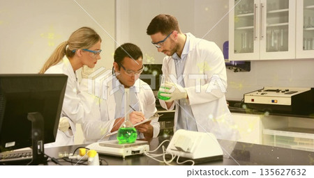 Measuring solutions and recording data at lab bench, chemists in lab coats and goggles with flasks Measuring solutions and recording data at lab bench, chemists in lab coats and goggles with flasks 135627632