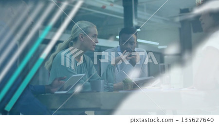 Blonde woman and colleagues discussing around wooden table in meeting room with tablet and mugs Blonde woman and colleagues discussing around wooden table in meeting room with tablet and mugs 135627640