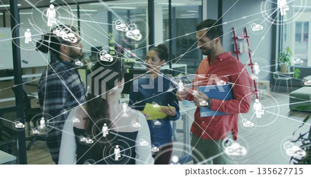 Collaborating team of five discussing project in office, with colored folders and network icons Collaborating team of five discussing project in office, with colored folders and network icons 135627715