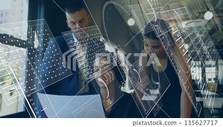 Collaborating team examining printed document on desk in office, coffee cup, glasses, AR overlays 135627717